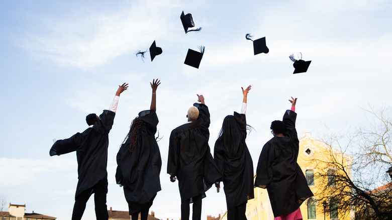 people throwing their graduation caps