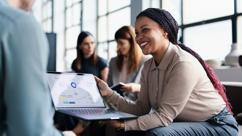 Professional sharing business strategy on a laptop in a meeting