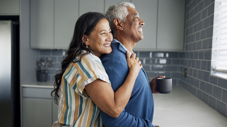 an older couple standing in the kitchen