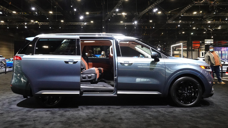 A silver 2022 Kia Carnival on display with its right sliding door open
