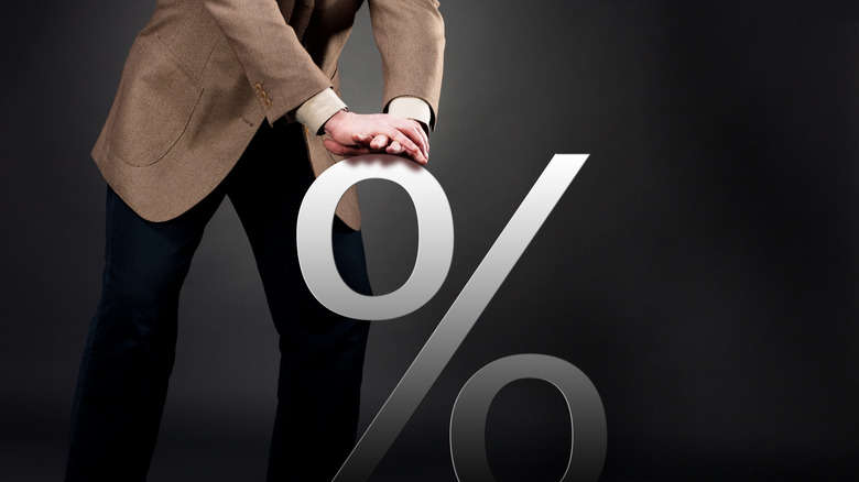man pushing down percentage symbol