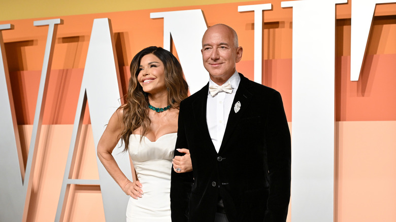 Jeff Bezos and Lauren Sanchez linking arms at a Vanity Fair event