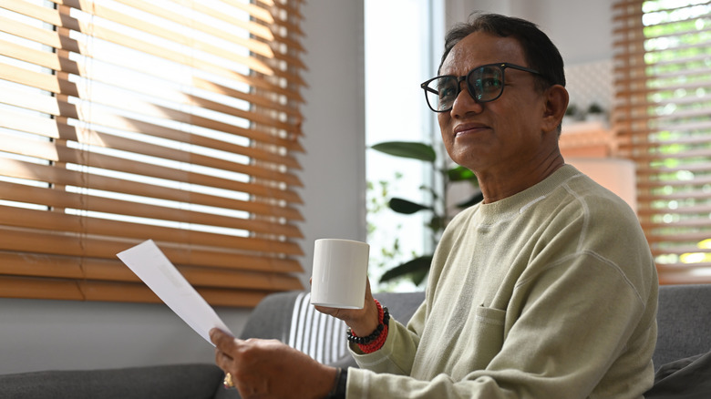 An older man looking content as he reviews a financial document