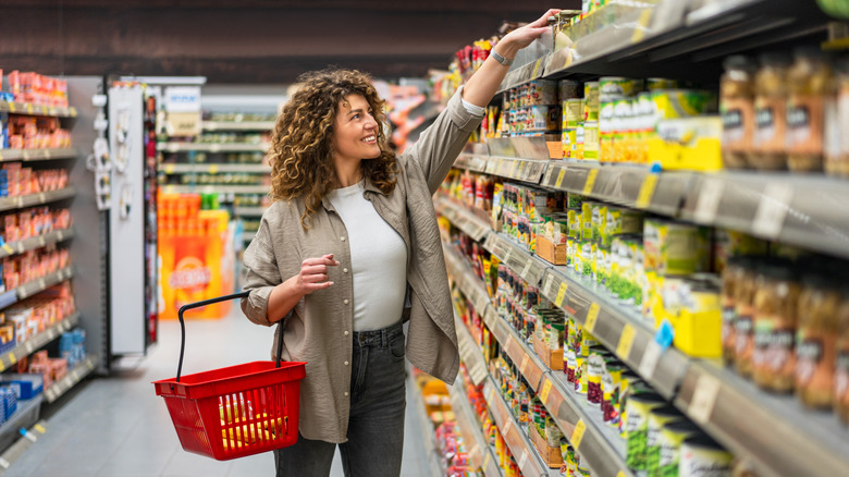 A woman happily shopping for groceries.