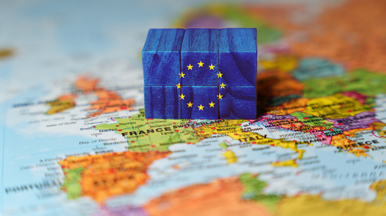 Block of EU flag over the map of Europe