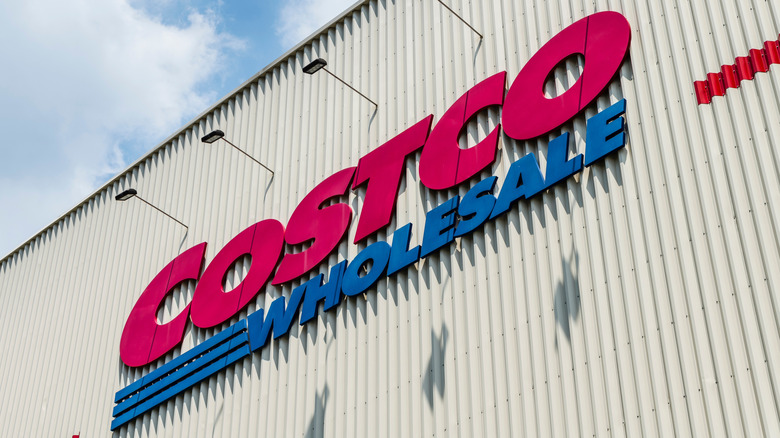 A Costco Wholesale storefront on a bright blue day, angled on the signage