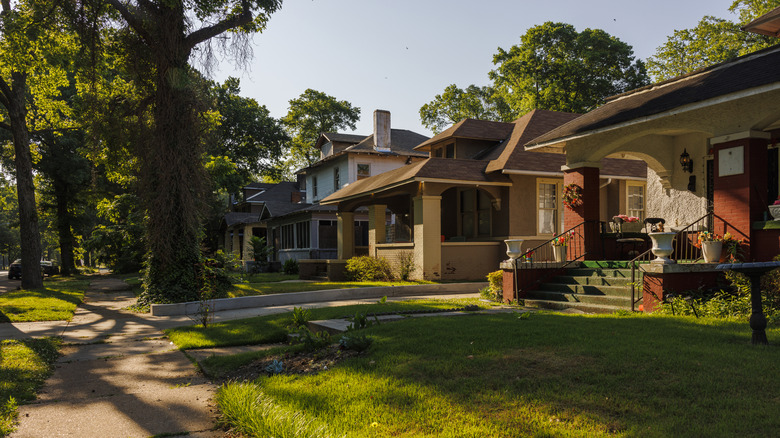 The sun setting over a row of older houses with old-fashioned front porches on old-tree lined street in Memphis, Tennessee