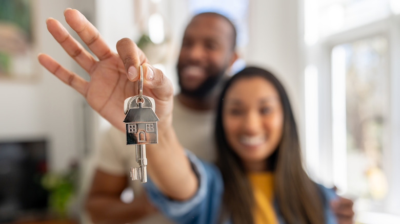 Couple holding keys to a home