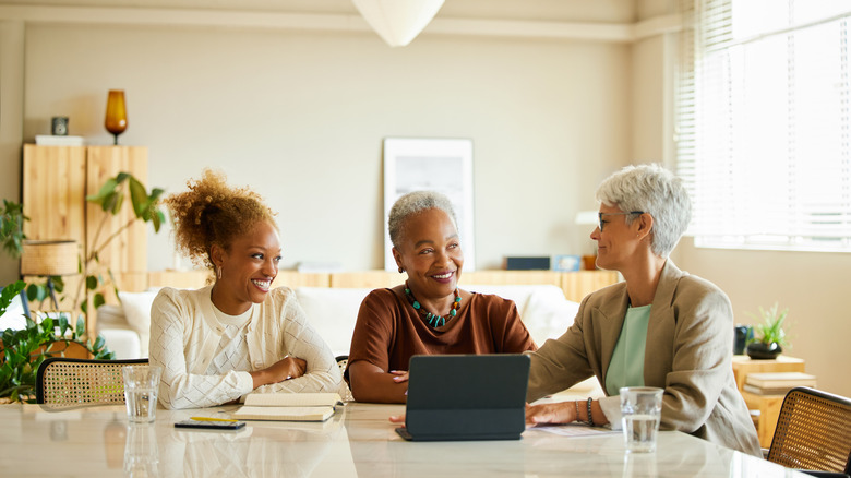 Three women smiling at a table