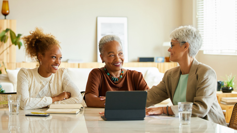 Three women smiling at a table