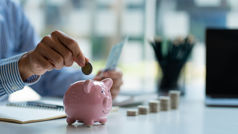 Man puts money in a piggy bank