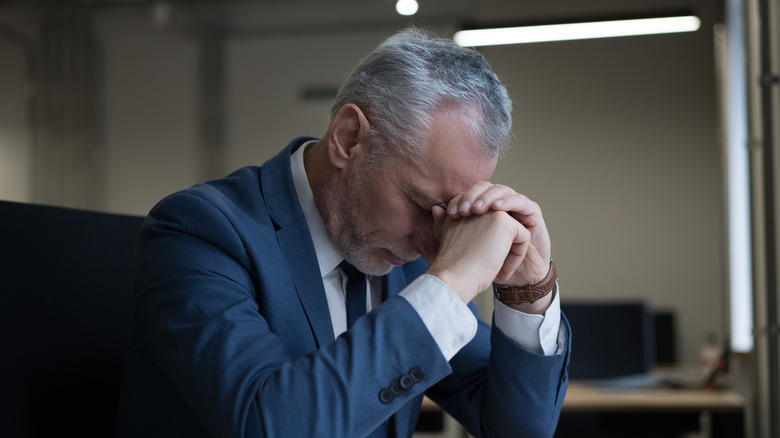 Portrait of tired stressed businessman sitting in office