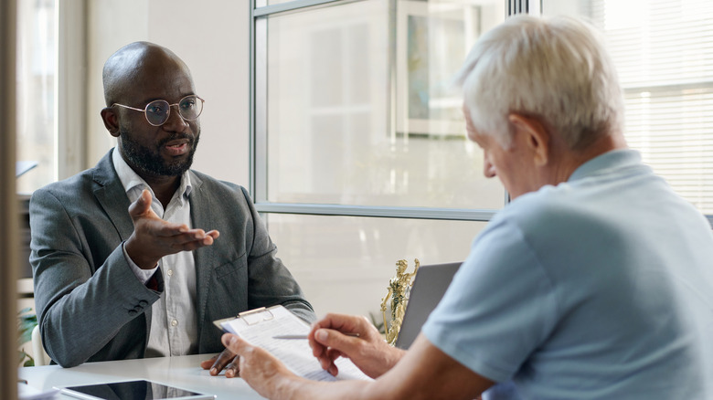 Older man speaking to a lawyer about setting up a trust