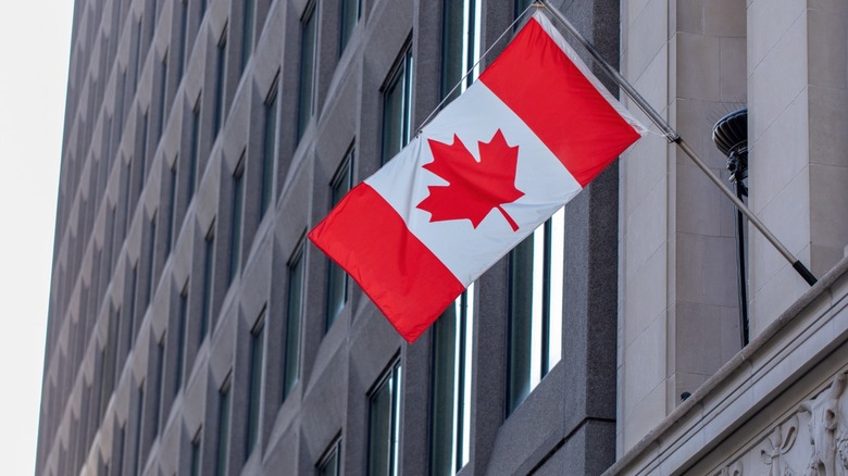 A Canadian flag hanging on a government building.