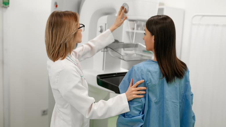 A woman getting checked for cancer with a mammogram.