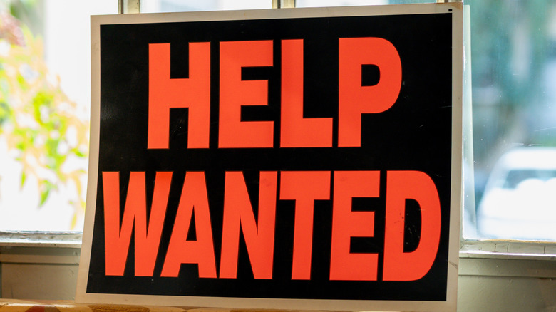 Help wanted sign displayed in the window of a door