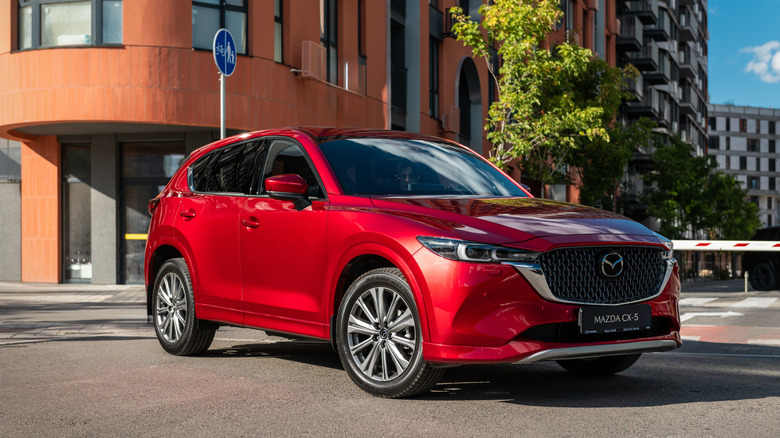 A red Mazda CX-5 on a city street.
