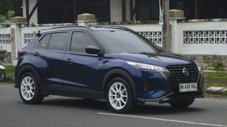 A blue hatchback 2022 Nissan Kicks E-Power is passing through the streets