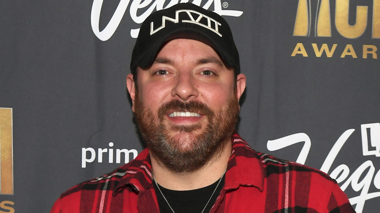 Chris Young smiling in front of black back drop