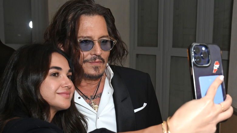 Johnny Depp posing with fan for picture