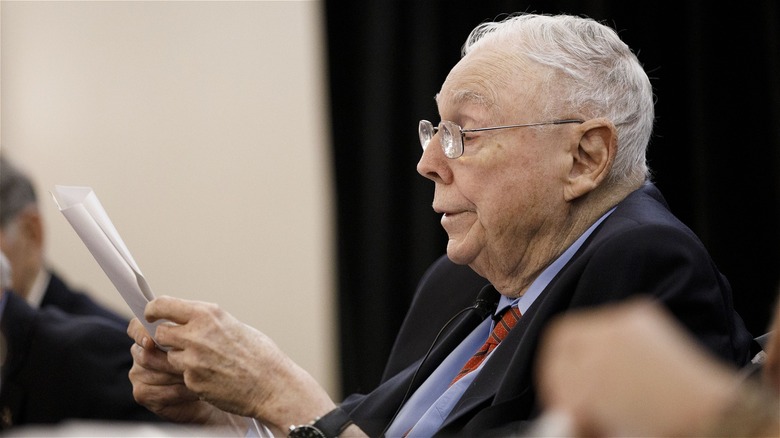 Charles Munger looking over papers