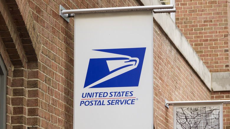 An United States Postal Service (USPS) is displayed outside of a delivery office