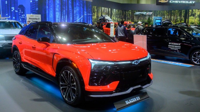 An orange Chevrolet Blazer EV on display at an international car show.