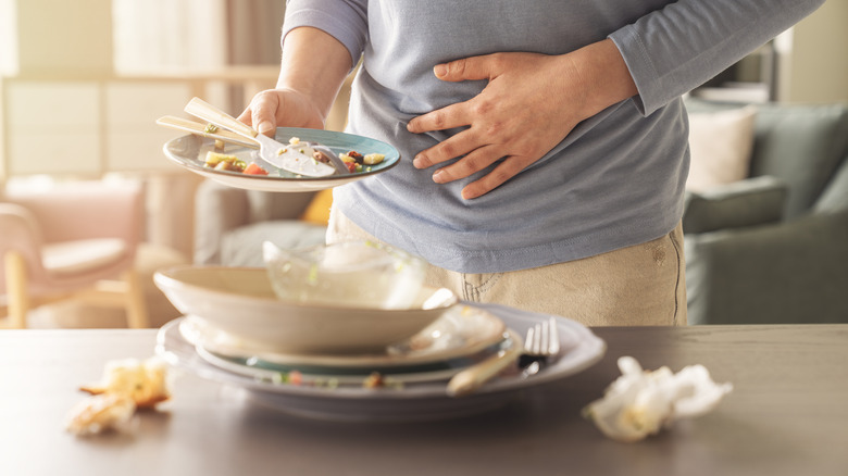 Person holding stomach after eating