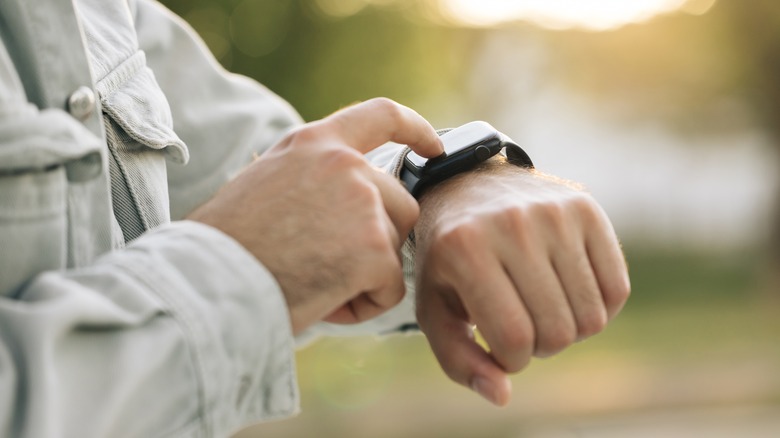 Man touching a smartwatch on his wrist