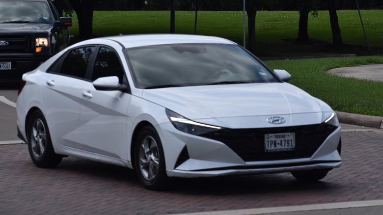 A white Hyundai Elantra near a nature reserve.