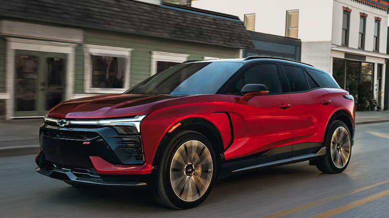 red Chevrolet Blazer EV moving through an empty old-fashioned downtown
