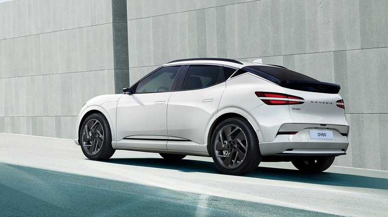 white Genesis GV60 in front of gray concrete wall