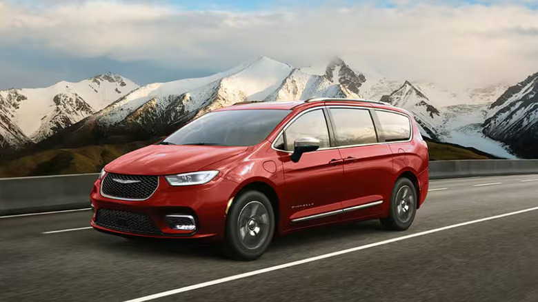 red Chrysler Pacifica Hybrid on roadway backed by snowcapped mountains