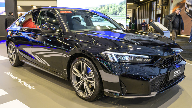 A black 2026 Honda Civic Hybrid on display at an autoshow.
