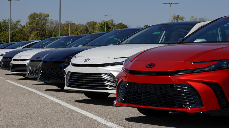 A lineup of Toyota Camry hybrids at a dealership.