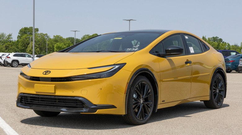 An aerial view of a yellow Toyota Prius V XV60 hybrid car driving.