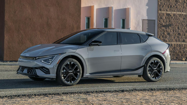 silver Kia EV6 parked in front of modernist building with textured exterior