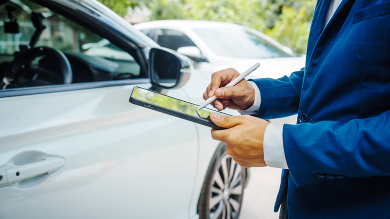 Insurance adjuster taking notes about a car acciden