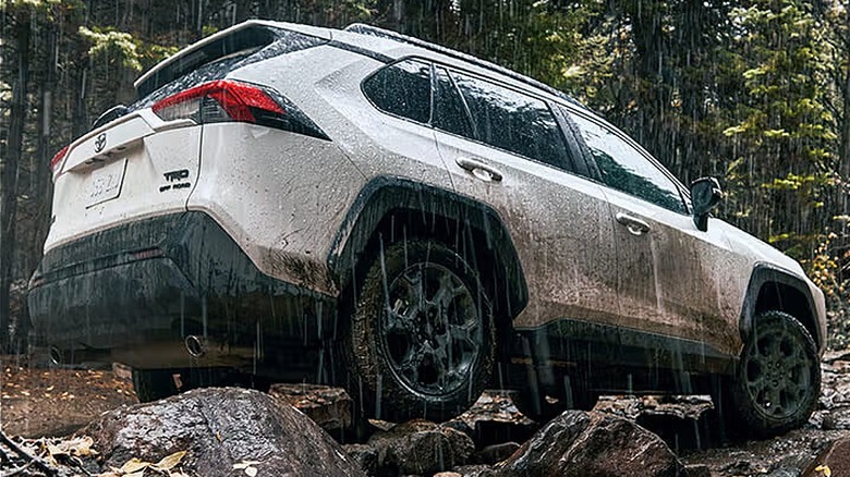 white 2025 Toyota RAV4 climbing rocks in the rain
