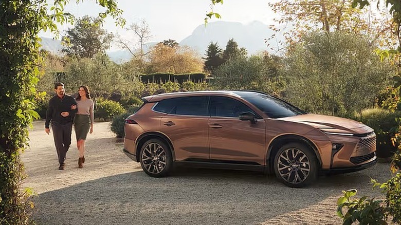 a couple walks arm-in-arm near a champagne 2026 Toyota Crown Signia