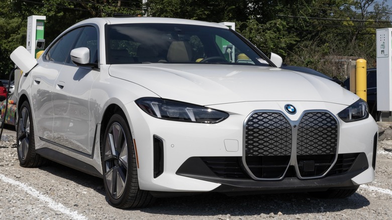 White BMW i4 plugged in at EV charging station