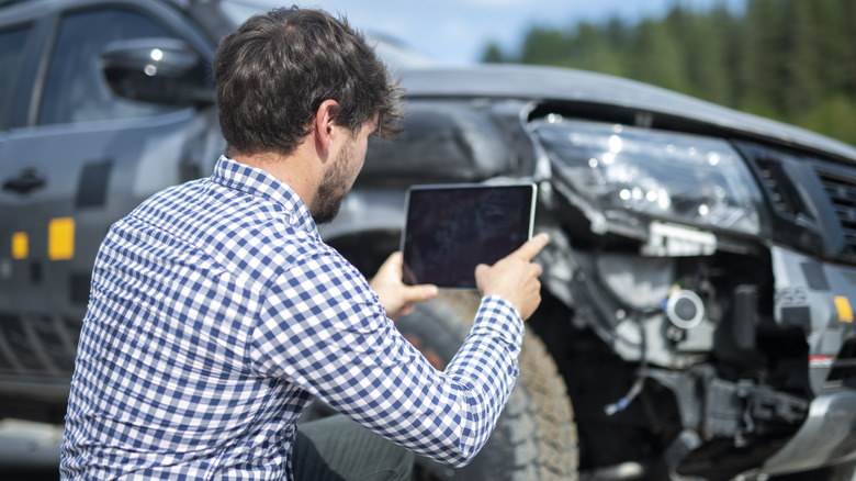 Insurance agent inspecting a damaged car