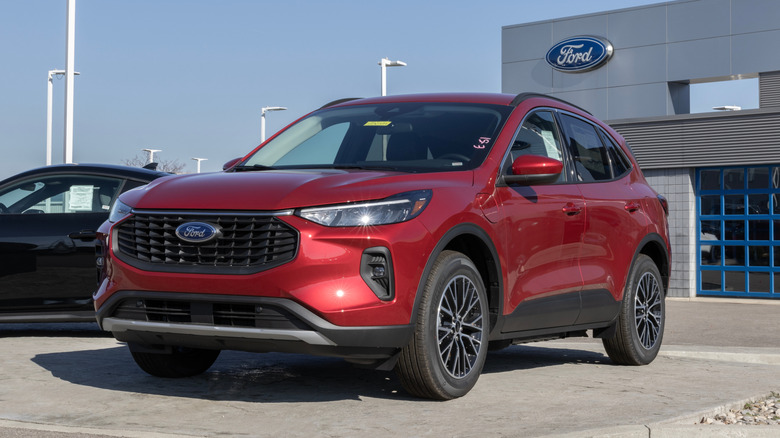 A red Ford Escape Hybrid sitting in a dealer's lot