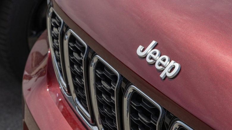 Front end of a redish Jeep Grand Cherokee