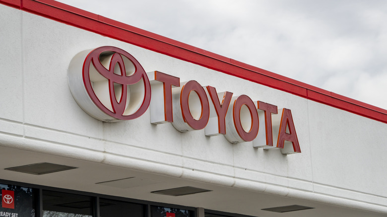 the sign for a Toyota dealership against a cloudy sky