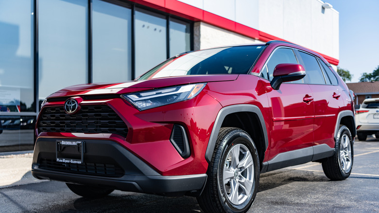 A red Toyota RAV4 in a parking lot.