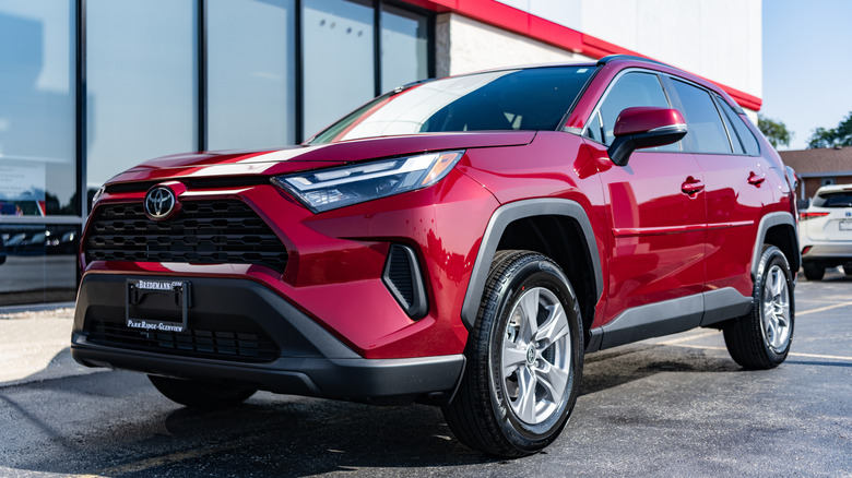 A red Toyota RAV4 in a parking lot.