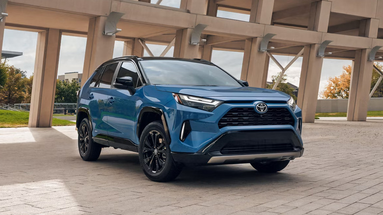 medium blue 2025 Toyota RAV4 Hybrid parked outside under a open-air structure