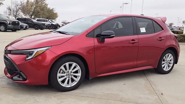A red 2026 Toyota Corolla Hatchback on display in a dealership parking lot