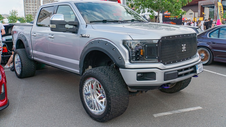 silver Ford pickup with lifts